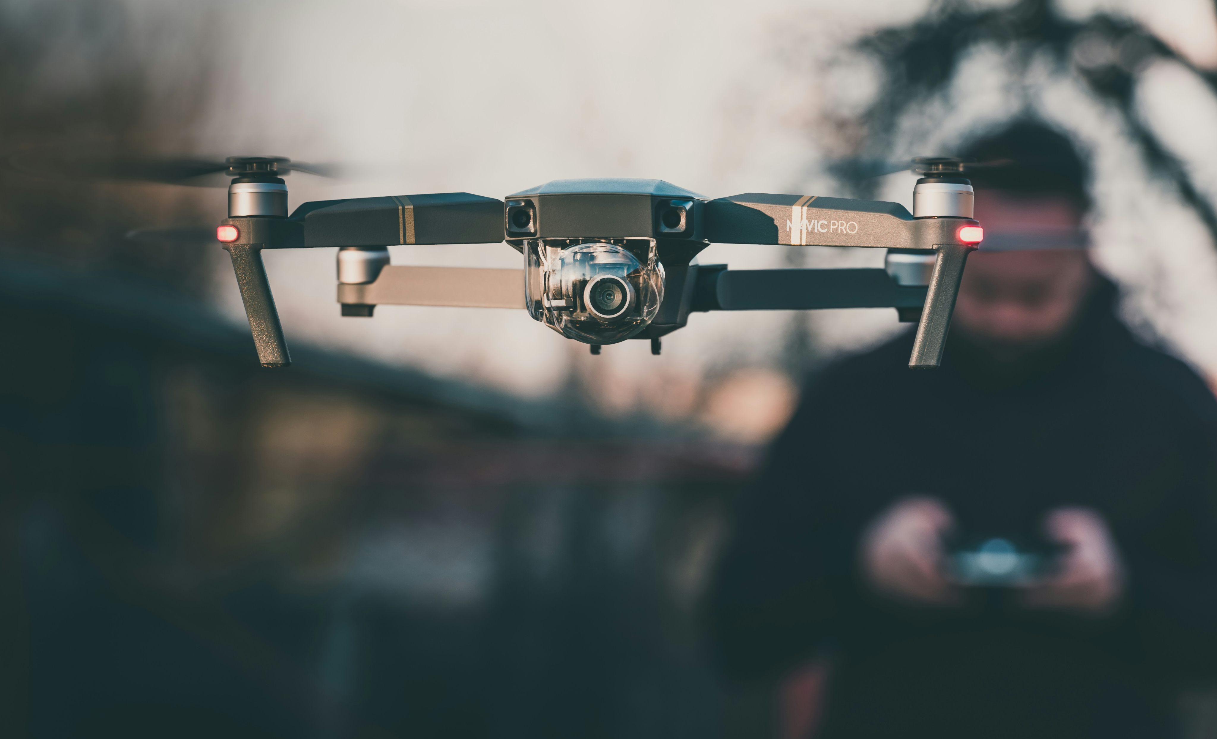 Close-up of a drone in flight with a person blurred behind it