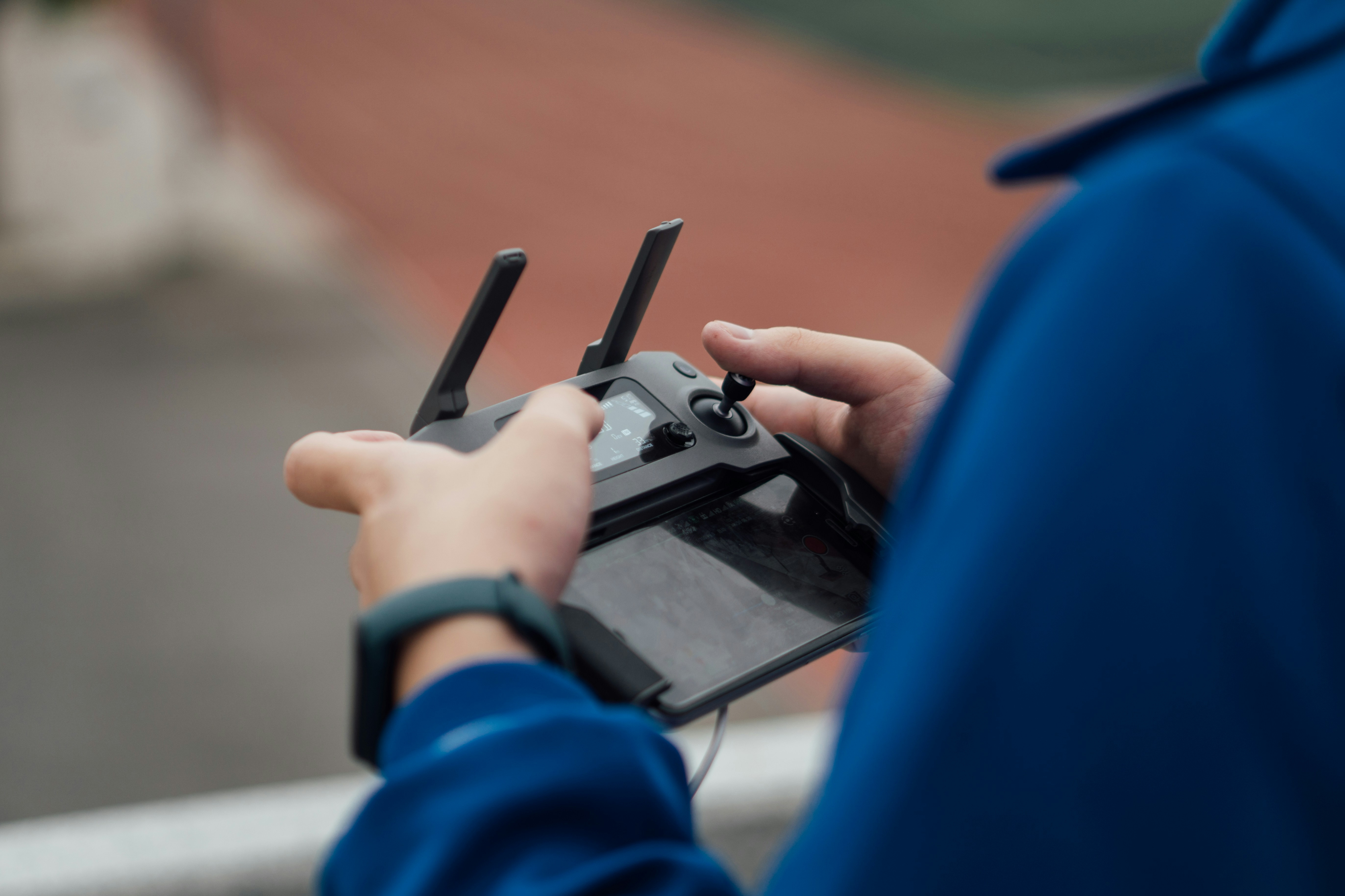 Close-up of hands operating a drone remote control outdoors